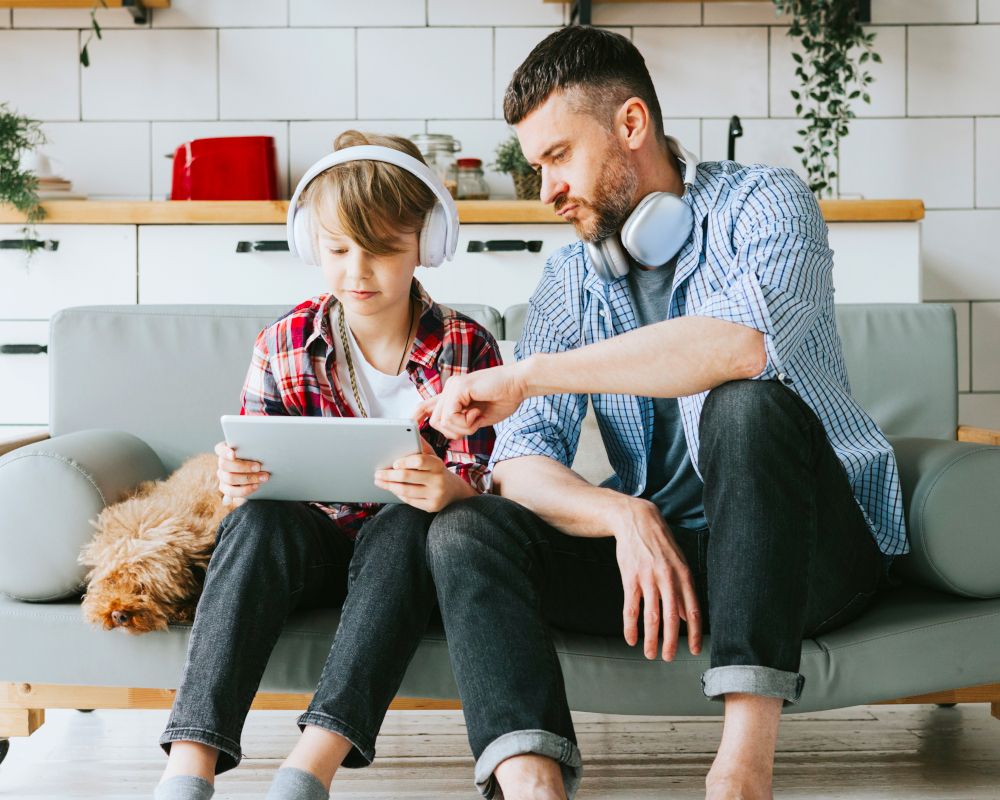 Padre e hijo mirando contenidos digitales.